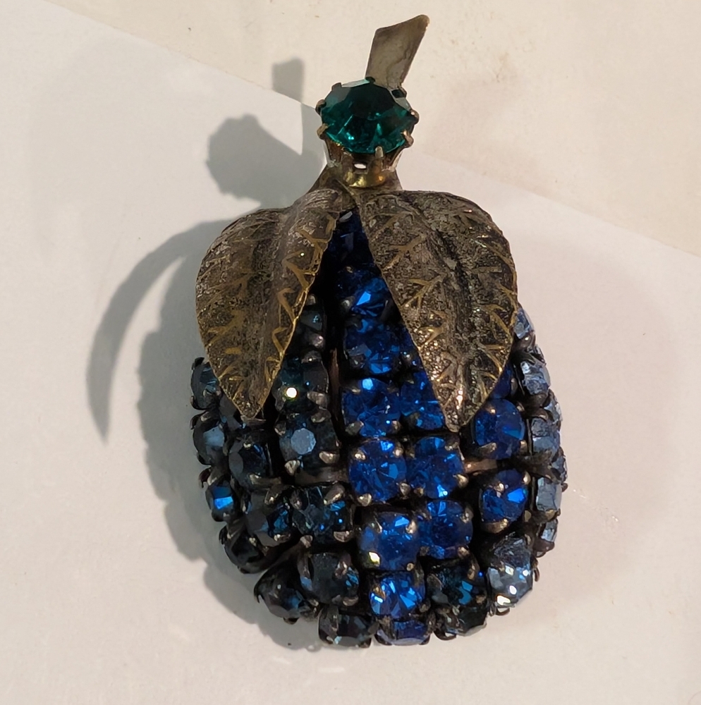 This is a vintage Hollycraft fruit brooch with light blue rhinestones